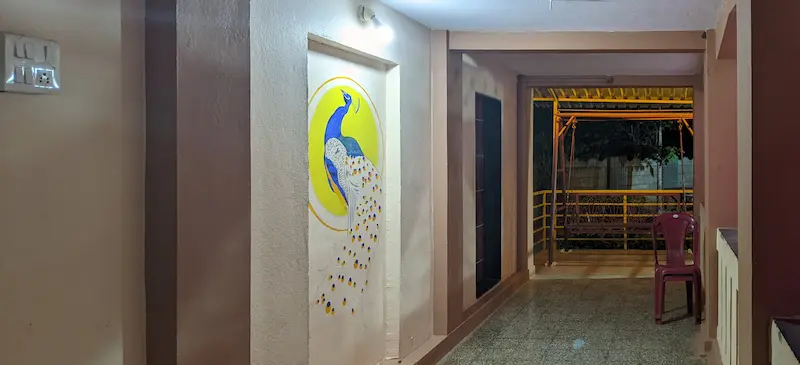 Image of a lobby that leads to a room, and a metal swing in the background.